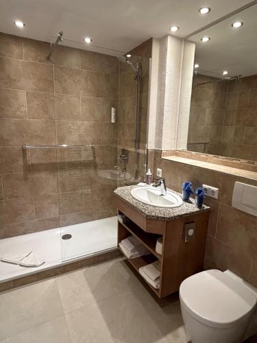 a bathroom with a toilet and a sink and a shower at Best Western Plus Hotel Alpenhof in Oberstdorf