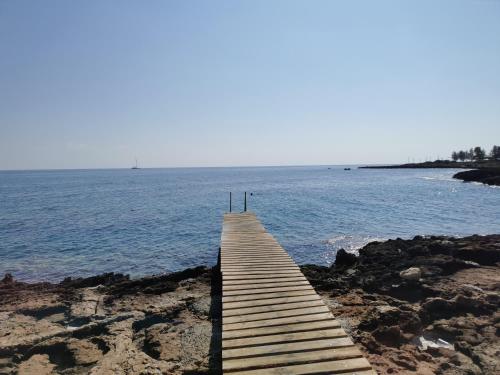 a wooden boardwalk leading into the water on a beach at Relax by the sea in Protaras