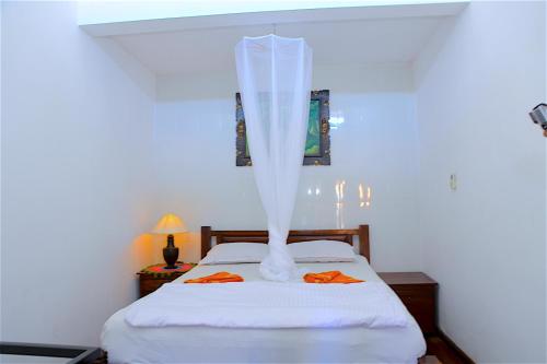a bedroom with a bed with a veil over it at Tirta Yoga Inn in Padangbai