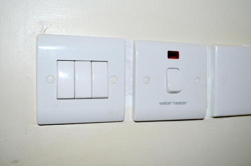 two white light switches on a white wall at Hotel Top Five in Kampala