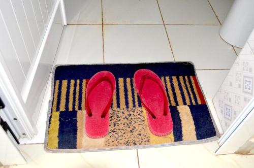 a pair of pink shoes on a rug on a floor at Hotel Top Five in Kampala