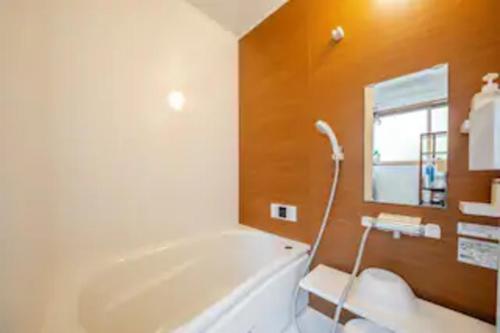 a bathroom with a tub and a sink and a mirror at Kanazawa-Hachitabi konjiki in Kanazawa