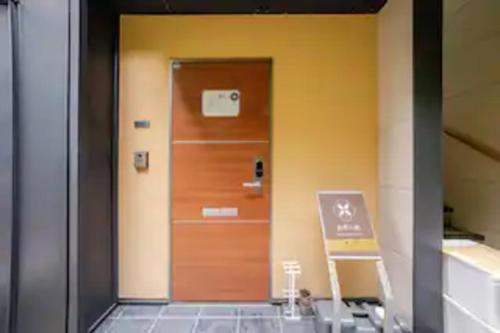 a wooden door in a building with a sign on it at Kanazawa-Hachitabi konjiki in Kanazawa