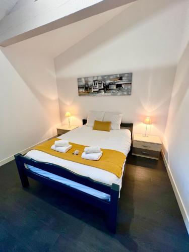 une chambre avec un grand lit avec deux tables de nuit dans l'établissement L'Oasis, Appartement Confort, Centre-ville, à La Tremblade