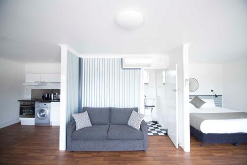 ein Schlafzimmer mit einem Bett und einem Sofa in einem Zimmer in der Unterkunft Siesta Central Apartments in Sale