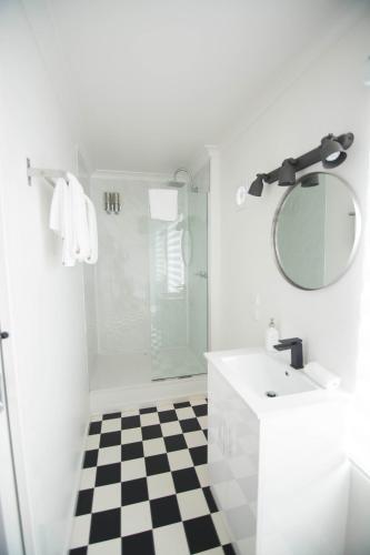 a white bathroom with a sink and a shower at Siesta Central Apartments in Sale