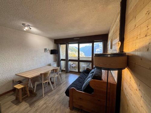 une chambre avec un lit, une table et une fenêtre dans l'établissement Studio cabine rénové 4 pers, à 150m des pistes - Auris en Oisans - FR-1-297-6, à Auris