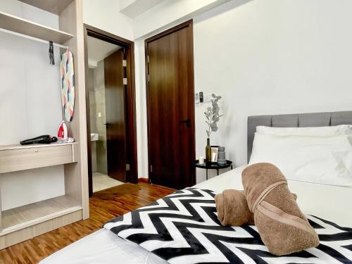 a bedroom with a bed with a black and white blanket at K Avenue Kota Kinabalu in Donggongon