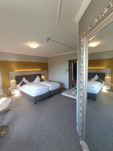 a hotel room with two beds and a mirror at BurgStadt-Hotel in Kastellaun