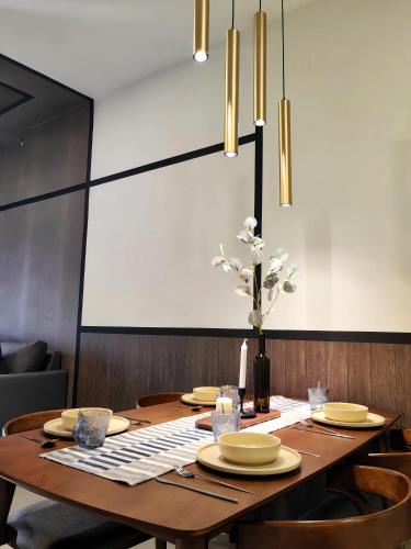 a dining room table with yellow plates and flowers on it at K Avenue Kota Kinabalu in Donggongon