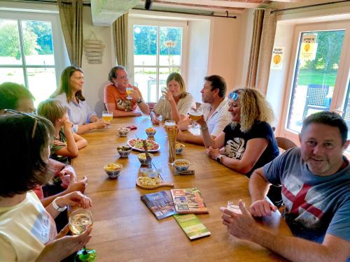 a group of people sitting around a table at La Demoiselle ô Bois - Gîte nature et confort aux portes de Chimay in Seloignes
