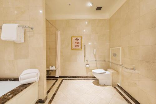 a bathroom with a tub and a toilet and a shower at Treasury Brisbane in Brisbane
