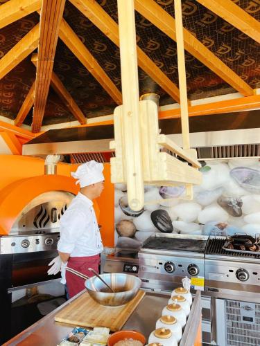 a chef standing in a kitchen preparing food at Boutique Citadel in Eforie Nord