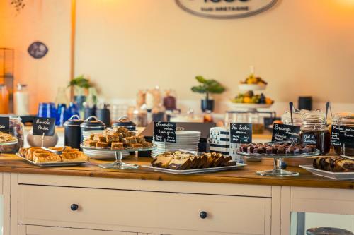 a buffet with different types of bread and pastries at Hotel de Charme Le Sud Bretagne in Pornichet