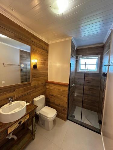 a bathroom with a toilet and a sink and a shower at Pousada Betânia in Gramado