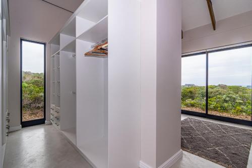 a hallway with white walls and large windows at Fynbos Barn in Gansbaai