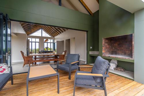 a living room with a table and chairs and a fireplace at Fynbos Barn in Gansbaai