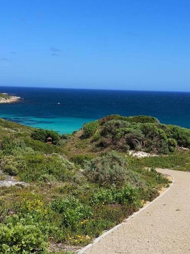 a road leading to a beach with the ocean at Fynbos Barn in Gansbaai