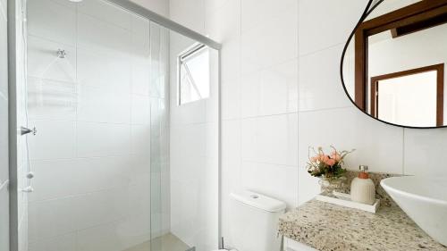 a white bathroom with a sink and a mirror at Residencial Praia do Sonho - PLH002 in Ilha dos Cardos