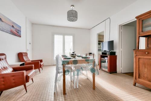 un salon avec une table et des chaises de salle à manger dans l'établissement 500m plage- Bassin d'Arcachon- Maison pour 6, à Lanton