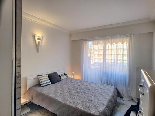 une chambre avec un grand lit et une fenêtre dans l'établissement Superbe vue mer terrasse - 218L MISS, à Cannes