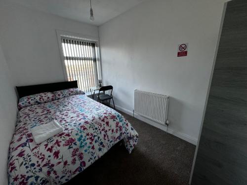 Un dormitorio con una cama con edredón y una ventana. en Double Bed BW2 Accrington Burnley, en Accrington