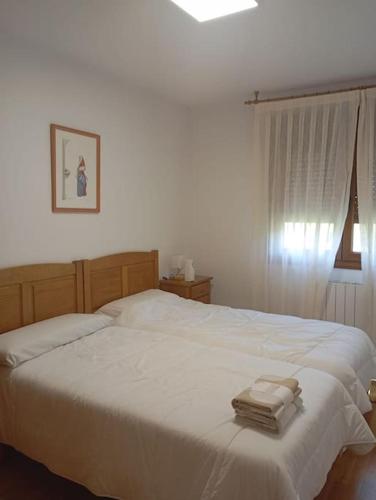 a bedroom with a white bed with two towels on it at R2R - Apto espacioso en Cabrales - 24B03 in Arenas de Cabrales