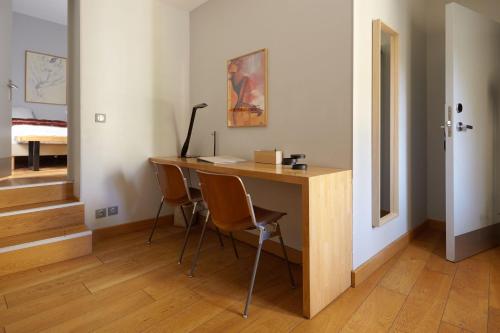 a room with a desk with chairs and a bed at Boutique Hôtel Entraigues in Uzès