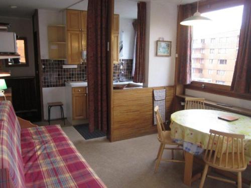 Una cocina y un comedor con mesa y sillas. en Studio 2 personnes proche pistes avec balcon - Animaux admis - FR-1-351-48, en La Plagne