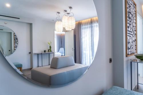 a mirror in a living room with a couch and a chair at Cayo Exclusive Resort & Spa in Elounda