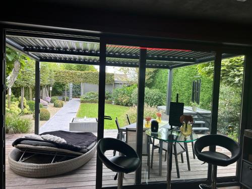 a patio with a table and chairs on a deck at La chambre du puits avec 2 jacuzzis , sauna et Hammam privatif in Tournai