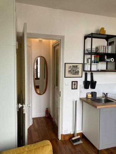 une cuisine avec un évier, un comptoir et un miroir dans l'établissement Studio cosy, lumineux et bien situé, à Lorient