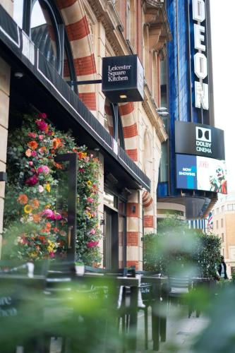 a busy city street with flowers on a building at Radisson Blu Hotel, London Leicester Square in London