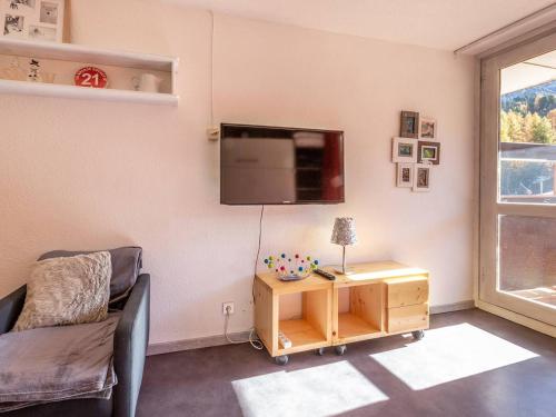 un salon avec un canapé et une télévision au mur dans l'établissement Studio rénové à Plagne Centre, accès direct pistes de ski, balcon, parking gratuit - FR-1-351-79, à La Plagne