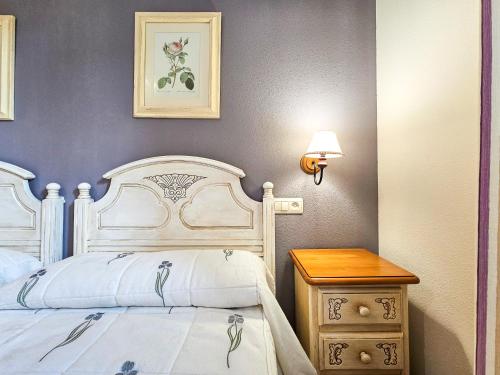 a bedroom with a white bed and a wooden table at Apartamentos Casa Boira 3000 in Gavín