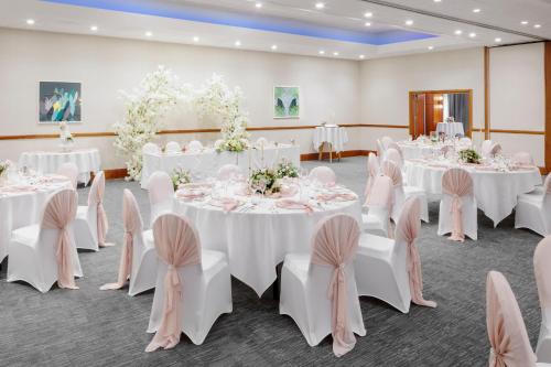 a room with white tables and chairs and flowers at Holiday Inn Leicester City by IHG in Leicester