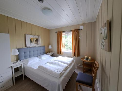 a bedroom with a large white bed and a window at Sandli Overnatting in Alvdal