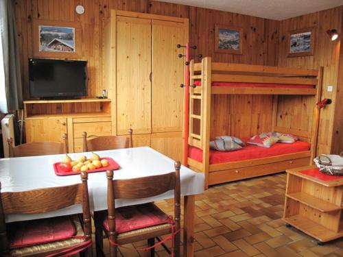 une chambre avec deux lits superposés et une table dans l'établissement Appt ski-in/ski-out avec lit gigogne et casier à skis - FR-1-351-57, à La Plagne