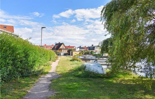 a path next to a body of water with houses at Cozy Home In Karlskrona With Kitchen in Karlskrona