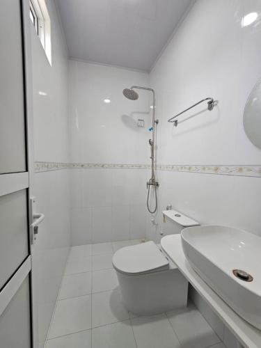 a white bathroom with a toilet and a sink at Bon Abri Maldives in Manadhoo