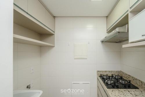 a white bathroom with a stove and a sink at Studio em cond. com piscina e academia - LHG1603 in Goiânia