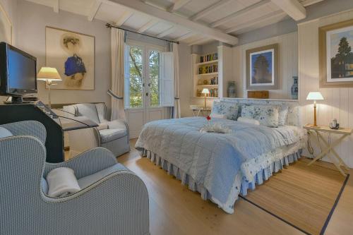 een slaapkamer met een bed, een bank en een tv bij Villa Federica 17 in Manciano