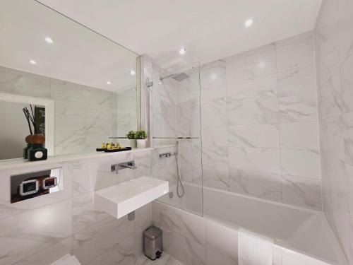 a white bathroom with a sink and a shower at Abbey Corner by Nivaas 2-Located in the heart of the city centre-5 minute walk to train station-20 minutes to London via train in Reading