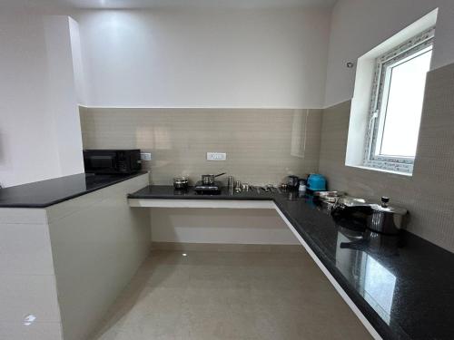 a kitchen with black counter tops and a sink at HOMESTAY - AC 1 BHK STUDIO NEAR AlRPORT in Chennai