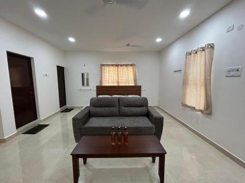 a living room with a couch and a table at HOMESTAY - AC 1 BHK STUDIO NEAR AlRPORT in Chennai
