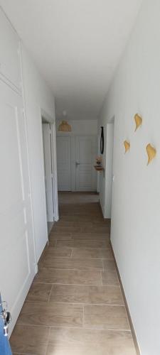 a hallway with white walls and a tile floor at Gîte Du Bas Bagneux, 7 kms du Zoo de Beauval - parking gratuit in Mareuil-sur-Cher