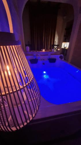 a large tub in a room with blue lighting at L'Edicola - SUITE - in Pulsano