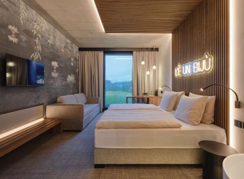 a hotel room with a large bed and a couch at Dorint Resort & Spa Locarno-Riazzino in Riazzino