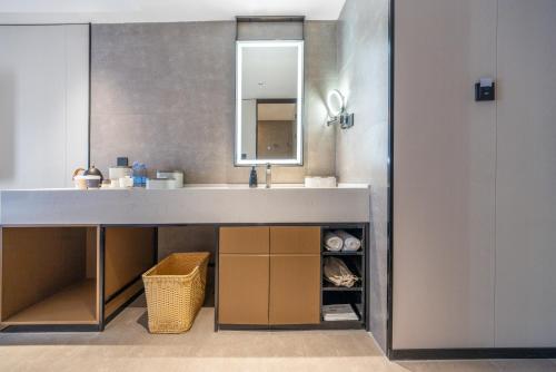 a bathroom with a sink and a mirror at Atour Hotel Nanjing South Railway Station North Square in Jiangning