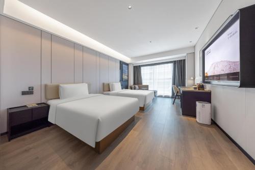 a hotel room with two beds and a flat screen tv at Atour Hotel Nanjing South Railway Station North Square in Jiangning